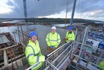 Celebrating reaching the highpoint in the construction of the five-storey apartment building at North Quay, in Hayle, are Corinthian Homes construction director David Speight (centre) with (left) architect Rob Hebblethwaite, of FCB Studios, and Richard Sc